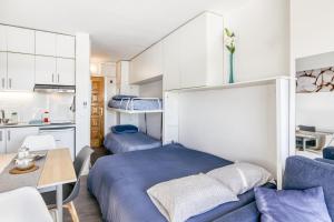 a bedroom with two beds and a table and a kitchen at Ventana Loft in Empuriabrava