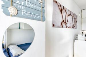 a bathroom with a mirror and a beach sign on the wall at Ventana Loft in Empuriabrava +16 photos