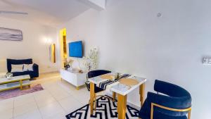 a living room with a table and blue chairs at Diani Hideouts 2 in Kwale +23 photos