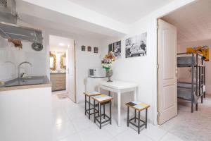 a kitchen with a white counter and stools in it at La Fabriqueta Studio in Ríudecañas