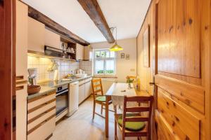 a kitchen with wooden cabinets and a table and chairs at Ferienwohnung Gute Stube in Veckenstedt