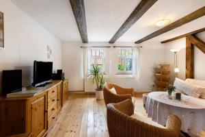 a living room with a table and a tv at Ferienwohnung Gute Stube in Veckenstedt