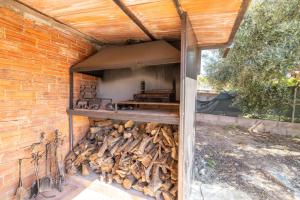 a building with a pile of fire wood underneath it at La Fabriqueta Studio in Ríudecañas