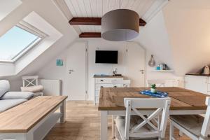 a kitchen and dining room with a wooden table and chairs at Ferienwohnung Backbord Deichhausen in Büsumer Deichhausen