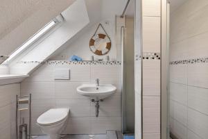 a bathroom with a toilet and a sink at Ferienwohnung Backbord Deichhausen in Büsumer Deichhausen +13 photos