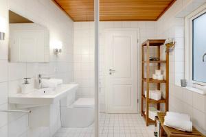 ein weißes Badezimmer mit Waschbecken und Toilette in der Unterkunft Olendeel in Gelting + 25 Fotos