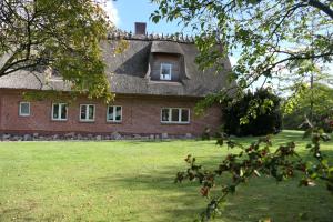 ein altes Backsteinhaus mit einem Fenster zum Hof in der Unterkunft Olendeel in Gelting