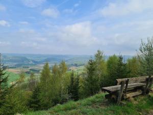 a wooden bench sitting on top of a hill at Ferienwohnungen Dorfliebe Dörnberg in Bestwig