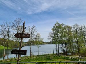 a sign in front of a body of water at Ferienwohnungen Dorfliebe Dörnberg in Bestwig