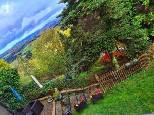 a view of a garden with flowers and a fence at Ferienwohnungen Dorfliebe Dörnberg in Bestwig