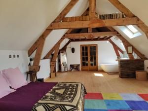 a attic bedroom with a bed and a bath tub at Longère de charme in Kervignac