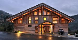 a large wooden house with a lot of windows at Chalet Enigma in La Clusaz