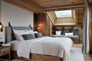 a bedroom with a large white bed and a window at Chalet Enigma in La Clusaz