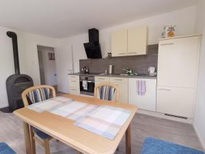 a kitchen with a wooden table and chairs in a room at Ferienwohnung bei Bojko in Oberkirch +3 photos