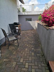 a patio with two chairs and a table and flowers at Ferienwohnung bei Bojko in Oberkirch