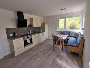a living room with a table and a couch and a kitchen at Ferienwohnung bei Bojko in Oberkirch