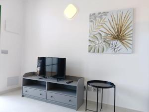 a living room with a tv and a stool at Torres in Antigua