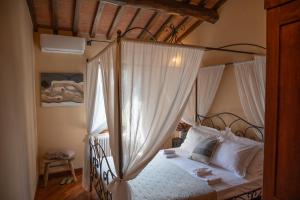 a bedroom with a canopy bed with white curtains at Tuscan Retreat Private Spa Villa in Lucignano