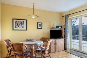 a dining room with a table and chairs and a tv at Ferienwohnung Tannenblick 1-3 in Oberhof