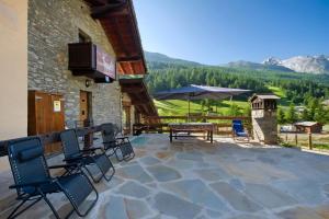 a patio with chairs and a table with a view of a mountain at Arthemisia - Rhêmes-Notre-Dame in Rhêmes-Notre-Dame