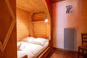 a small room with a bed in a wooden cabin at Appartement Roméo in Champagny-en-Vanoise +17 photos