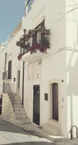 a white building with stairs and a balcony at Appartamento Panorama in Ostuni