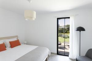 a white bedroom with a bed and a chair at Villa Catherine in Ghisonaccia +13 photos