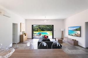 a living room with a couch and a view of a pool at Villa Catherine in Ghisonaccia