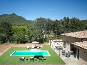 an image of a swimming pool with chairs and an umbrella at Villa Catherine in Ghisonaccia