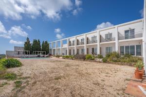 a large white building with a yard in front of it at Alto da Lua in Bordeira