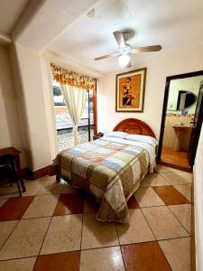 a bedroom with a bed and a ceiling fan at Hotel Nivel 5 in Macas