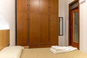 a bedroom with a bed with a large wooden cabinet at Vito 80 in Chiaramonte Gulfi