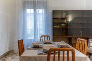 a dining room with a table with chairs and a kitchen at Vito 80 in Chiaramonte Gulfi