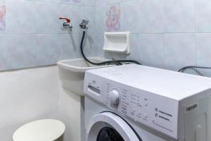 a bathroom with a washing machine and a toilet at Vito 80 in Chiaramonte Gulfi