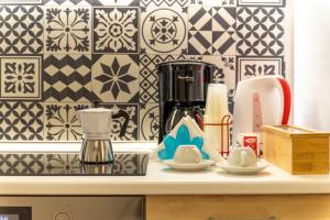 a kitchen counter top with a coffee maker and cups at Vito 80 in Chiaramonte Gulfi +13 photos