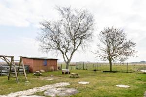 a park with a bench and a tree and a shed at Mika in Oesterdeichstrich