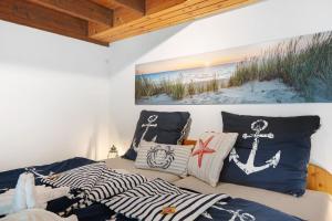 a bedroom with two beds with pillows and a painting at Ferienhaus Karlsminde in Waabs