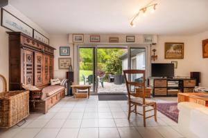 a living room with a couch and a television at Ty Clafout wifi parking in Saint-Nolff