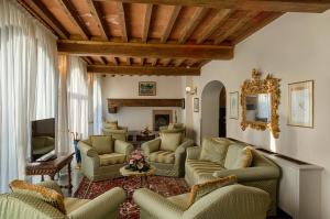 a living room with couches chairs and a television at Villa Olmi Firenze in Florence