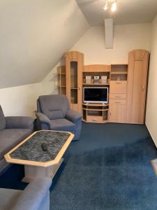 a living room with a couch and chairs and a table at Ferienwohnungen am Louisenteich in Frauendorf