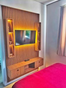 a room with a television on a wall at Brisa do Vale Loft 802 - Prox Centro e Oktoberfest - Piscina e WiFi in Blumenau