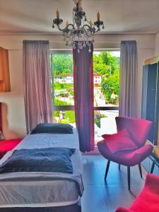 a bedroom with a bed and a chandelier and a window at Brisa do Vale Loft 802 - Prox Centro e Oktoberfest - Piscina e WiFi in Blumenau
