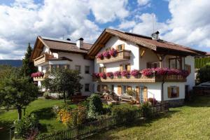 a large white house with flowers on the balconies at Haus Alpenblick Apt Brunelle in Laion