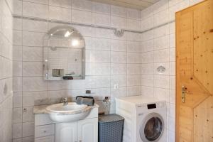 a bathroom with a sink and a washing machine at Hof Almfrieden - Dormitz in Nassereith +20 photos