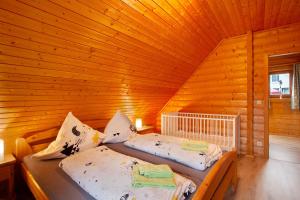 a bedroom with two beds in a wooden cabin at Holzhaus Zum Radekopf mit Whirlpool in Medebach