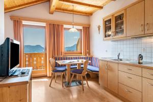 a kitchen with a table and chairs and a window at Haus Alpenblick Apt Brunelle in Laion