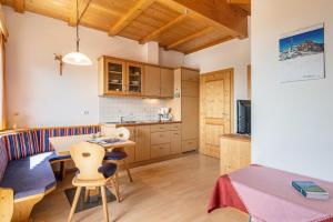 a kitchen and living room with a table and chairs at Haus Alpenblick Apt Brunelle in Laion +24 photos