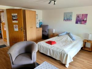 a small bedroom with a bed and a chair at Ferienwohnung Brixius in Koblenz