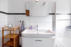 a white bathroom with a sink and a mirror at Domäne Bollinger Morbach in Morbach +25 photos