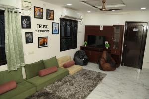 a living room with a green couch and a tv at Connect Backpackers Hostel in Chennai